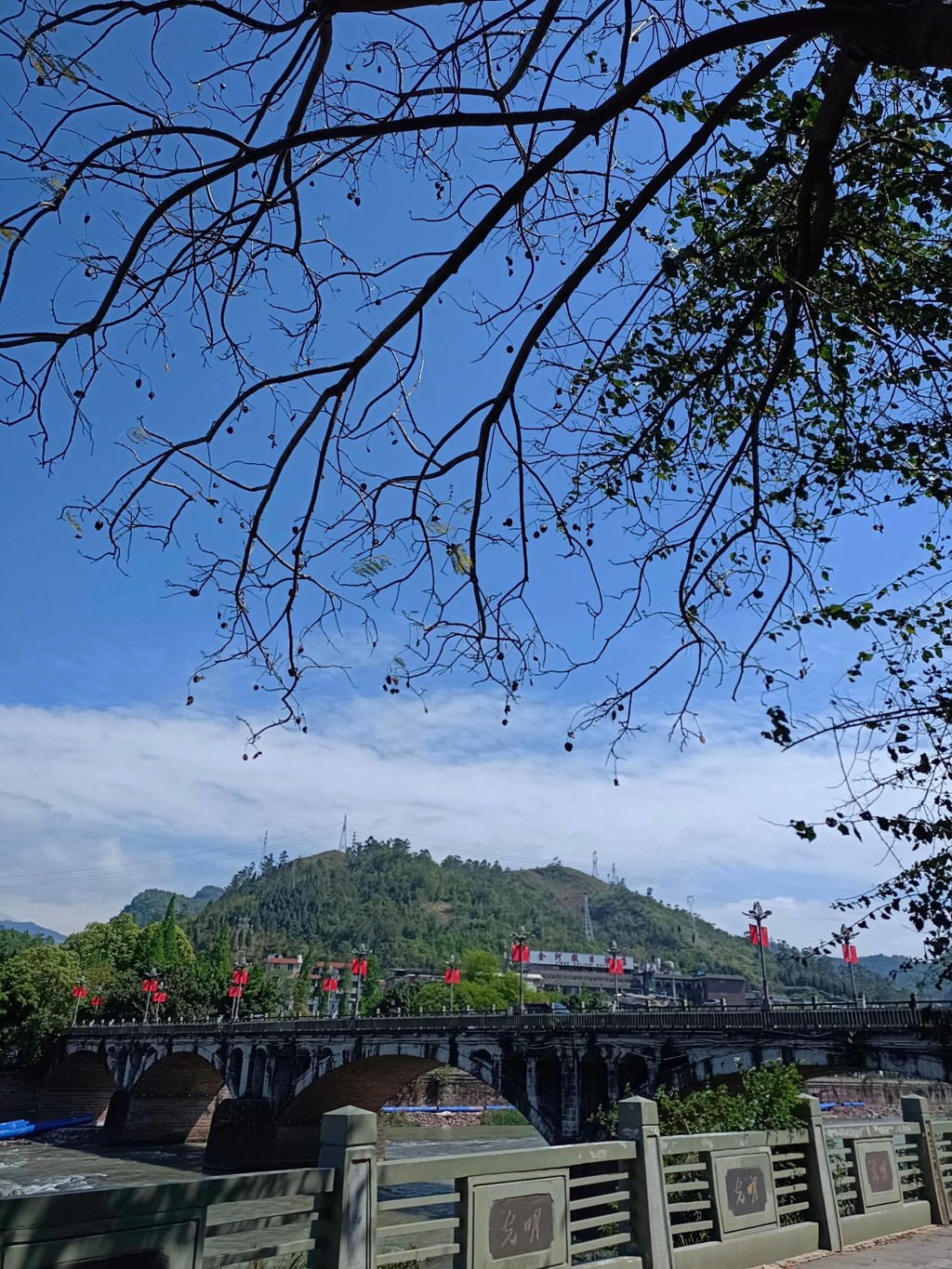 走在马边的街头，才发现小城的浪漫全藏在日常里。晴天的老石桥框着蓝天，枝桠剪影落在桥面上，自带复古滤镜；傍晚的河边，有人钓鱼、有人散步，河水映着远山和云，安静得不像话；菜市场里人声鼎沸，新鲜的蔬菜带着泥土气，这才是最真实的烟火气。滨河步道的木栈道延伸向远方，雾蒙蒙的远山像水墨画，走在上面，连风都慢了下来。不用赶时间，不用跑景点，在马边，随便走走都是舒服的日常。