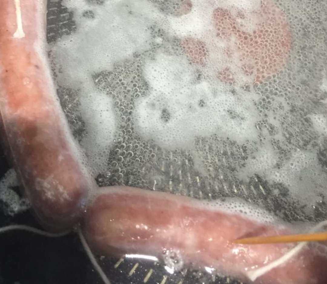 手拿着牙签扎烟熏腊肠表皮.png
