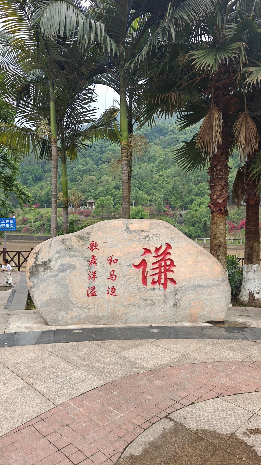 马边人的日常，一半藏在滨河步道，一半藏在熊猫广场。广场边的棕榈树、木栈道，还有刻着 “谦” 字的景观石，把小城的气质拿捏得刚刚好。沿着河边慢慢走，河水映着远山，云雾裹着青山，连风都带着慢悠悠的味道。不用特意找景点，就在熊猫广场周边散散步，吹吹河风，看看石头上的字，感受 “和马边，歌舞洋溢” 的温柔，这就是马边独有的慢生活呀